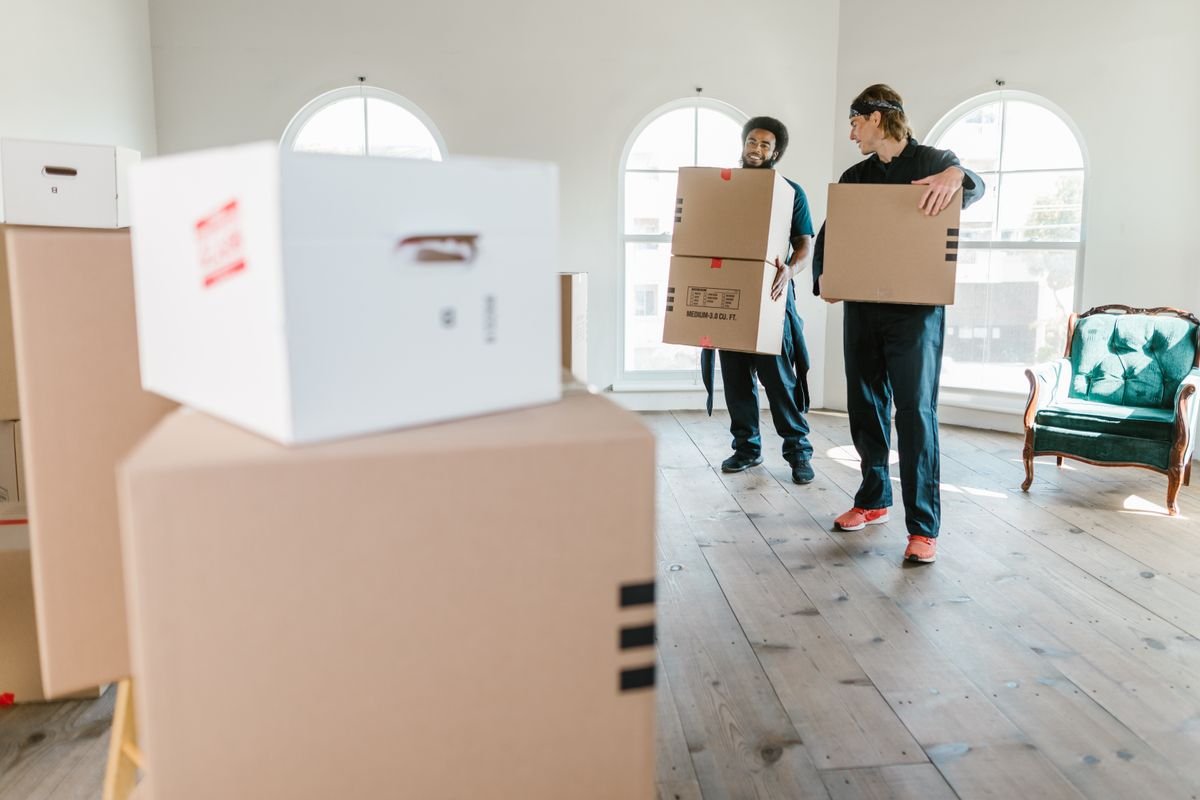 Movers carrying boxes inside a home