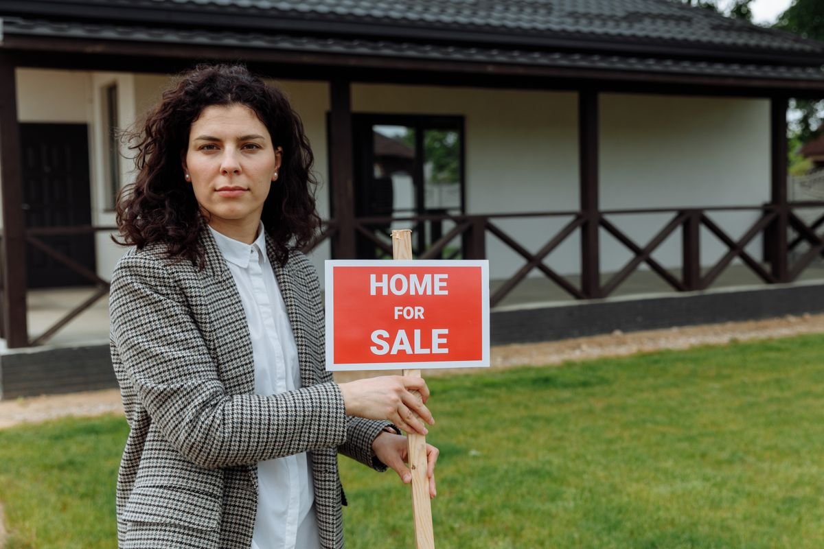 Real estate agent holding a property sign